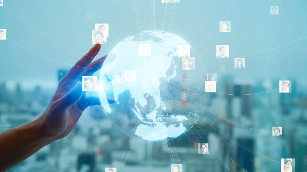 手のひらに浮かぶ透明な地球と、ネットワーク線で繋がった世界各地の人々のプロフィール画像。